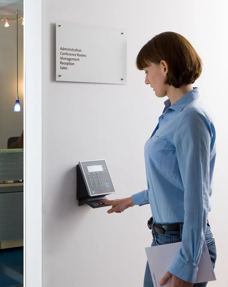 An employee presents her badge to the reader at the office entrance