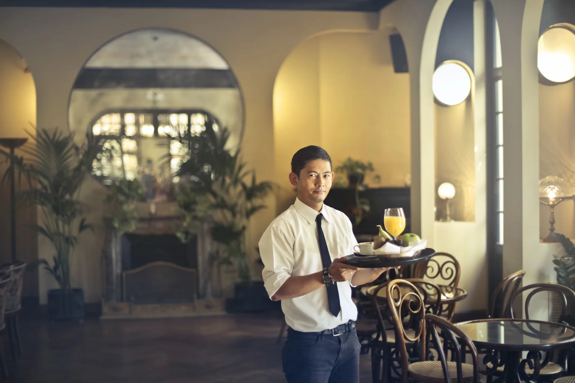 Waiter carrying a tray through a hotel restaurant